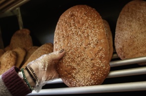 Χέρι αρτοπώλη κρατά λαγάνα