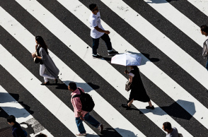 Κόσμος περπατάει σε διάβαση πεζών. 
