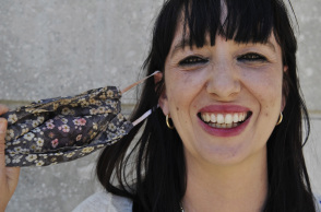 Γυναίκα έχει βγάλει τη μάσκα προστασίας της για τον κορωνοϊό και χαμογελά 