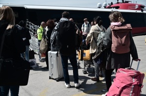 Επιβάτες με τις βαλίτσες ανά χείρας αναμένουν την επιβίβασή τους σε ταχύπλοο πλοίο στο λιμάνι του Πειραιά 