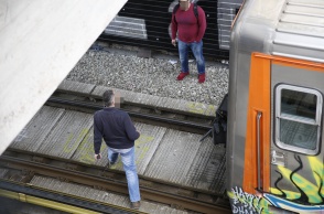 Δύο άνδρες στις γραμμές του Ηλεκτρικού κατά τις προσπάθειες απεγκλωβισμού ατόμου από τις ράγες