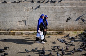 Γυναίκες περπατούν δίπλα από περιστέρια σε δρόμο στην Τουρκία