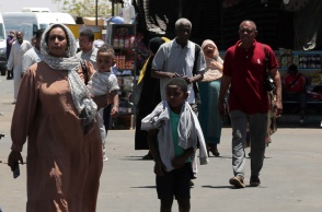 Γυναίκα με τα παιδιά της φεύγει από το Σουδάν μετά το ξέσπασμα των συρράξεων