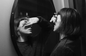 Γυναίκα καλύπτει τα μάτια της μπροστά σε καθρέφτη