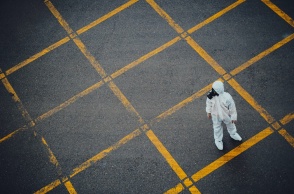 Άτομο με στολή προστασίας από πανδημία σε άδειο δρόμο