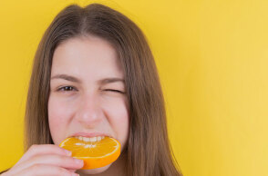 Κοπέλα δαγκώνει πορτοκάλι