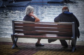 Συνταξιούχοι κάθονται σε παγκάκι κοντά σε μαρίνα