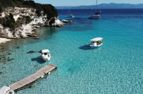 Παραλία των Παξών και μώλος όπου έχουν δέσει δύο καραβάκια