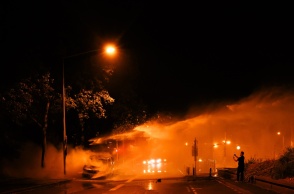 Φλεγόμενο λεωφορείο και πυροσβέστες που επιχειρούν για την ολοκληρωτική κατάσβεσή του