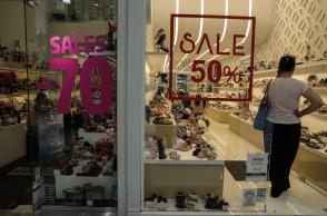 Γυναίκα σε βιτρίνα καταστήματος παπουτσιών με εκπτώσεις