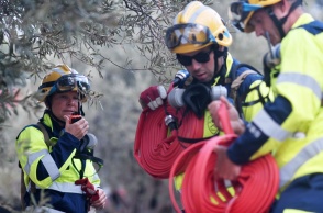 Πυροσβέστες με τις μάνικες ανά χείρας ετοιμάζονται να ριχτούν στο έργο της κατάσβεσης πυρκαγιάς
