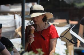 Γυναίκα απολαμβάνει ένα χωνάκι παγωτό στην προσπάθειά της να δροσιστεί