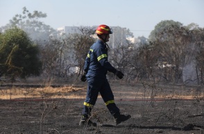 Πυροσβέστης σε σημείο όπου έχει πάρει φωτιά