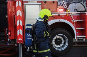 Πυροσβέστης μπροστά από πυροσβεστικό όχημα