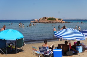 Λουόμενοι σε παραλία έχουν στήσει τις ομπρέλες τους