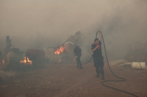 Πυροσβέστες και εθελοντές με μάνικα στα χέρια επιχειρούν για την κατάσβεση πυρκαγιάς