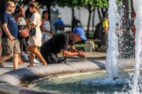 Άνδρας δροσίζεται βουτώντας τα χέρια του στο σιντριβάνι της πλατείας Συντάγματος