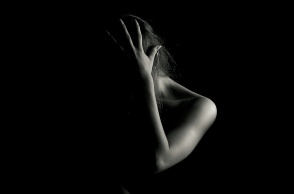 Γυναίκα με κρυμμένο το πρόσωπό της και το χέρι της στο κεφάλι σε ασπρόμαυρη φωτογραφία