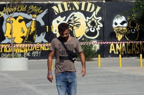 Άνδρας μπροστά από το σημείο όπου δολοφονήθηκε ο 29χρονος οπαδός της ΑΕΚ έξω από το γήπεδο της Νέας Φιλαδέλφειας