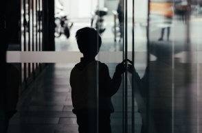 Παιδί σε σκοτεινό διάδρομο φαίνεται να φοβάται να βγει στο φως - Εικόνα που παραπέμπει σε κακοποίηση και bullying