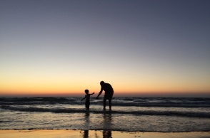 Παιδί παίζει με τον μπαμπά του στην ακροθαλασσιά