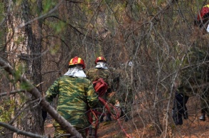 Άτομα που επιχειρούν για την κατάσβεση φωτιάς με τις μάνικες ανά χείρας
