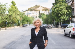 Η Πόπη Διαμαντάκου φωτογραφισμένη στη μέση του δρόμου με φόντο τον λόφο του Λυκαβηττού