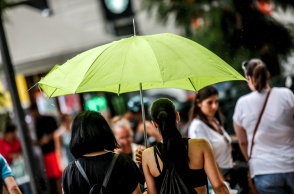 Γυναίκα με ομπρέλα προστατεύεται από τη βροχή