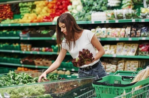 Γυναίκα διαλέγει σαλάτες σε πάγκο σούπερ μάρκετ