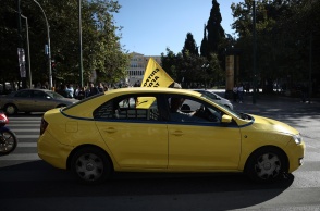 Απεργία ταξί: Οδηγός στο κέντρο της Αθήνας με σημαία κατά τη διάρκεια απεργίας
