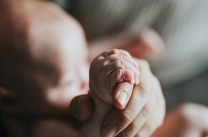 Χεράκι ατόμου κρατά το χεράκι μωρού