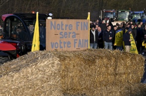 Αγρότες με παραταγμένα τα τρακτέρ τους και σανό σε δρόμο