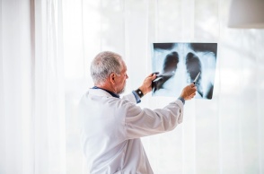 Ιατρός εξετάζει ακτινογραφία στην οποία διακρίνονται οι πνεύμονες