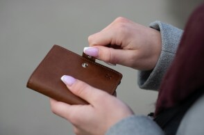 Γυναίκα κρατά στα χέρια της το πορτοφόλι της 