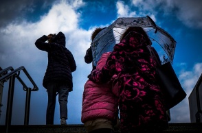 Γυναίκα με ομπρέλα προστατεύεται από ισχυρή βροχόπτωση