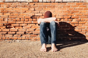 Παιδί που κρατά τα πόδια του με τα χέρια του και κρύβει το πρόσωπό του