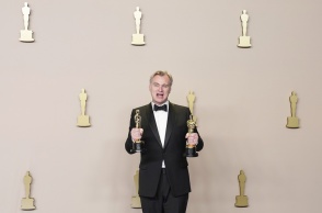Ο Κρίστοφερ Νόλαν κρατά στα χέρια του τα αγαλματίδια κατά τα Όσκαρς 2024
