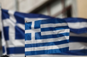 Ελληνική σημαία μπροστά από μία μεγαλύτερη ελληνική σημαία