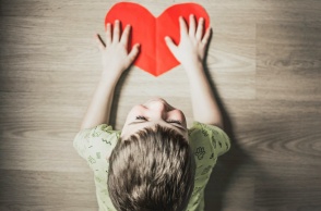 Παιδί κρατά σε επιφάνεια μία κόκκινη καρδιά - Λήψη από ψηλά 