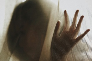 Γυναίκα πίσω από την κουρτίνα