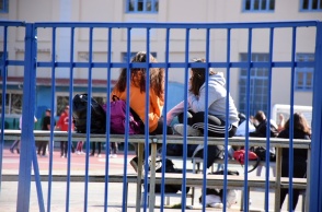 Μαθητές κάθονται σε σιδερένια κερκίδα στο προαύλιο σχολείου