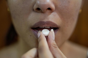 Γυναίκα παίρνει χάπι από στόματος για την ημικρανία