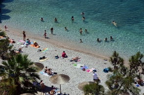 Λουόμενοι σε παραλία για λίγες στιγμές δροσιάς από τις υψηλές θερμοκρασίες