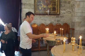 Ο Στέφανος Κασσελάκης ανάβει κεράκι σε εκκλησία κατά τη διάρκεια της περιοδείας του στα νησιά