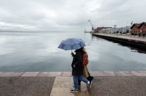 Κόσμος περπατάει έπειτα από βροχόπτωση στην παλιά παραλία της Θεσσαλονίκης