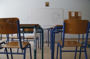 Σχολική αίθουσα άδεια από παιδιά με θρανία και καρέκλες και επίκεντρο στο βάθος της φωτογραφίας τον πίνακα