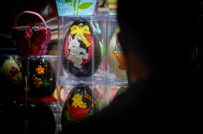 Σκιά ατόμου στα δεξιά του φακού που κοιτά βιτρίνα με σοκολατένια αυγά με φιγούρες από κινούμενα σχέδια