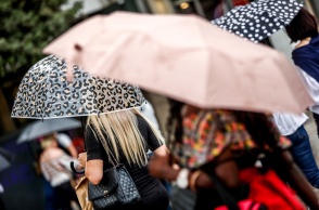 Πολίτες με ομπρέλα προστατεύονται από τη βροχή