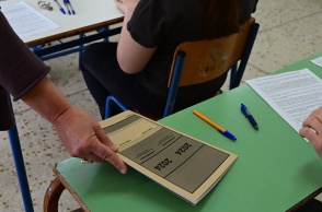 Καθηγήτρια μοιράζει τα τετράδια απαντήσεων που φέρουν στο εξώφυλλό τους το έτος διεξαγωγής των Πανελληνίων Εξετάσεων