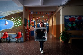 Γυναίκα με κάλπη στα χέρια σε διάδρομο σχολείου